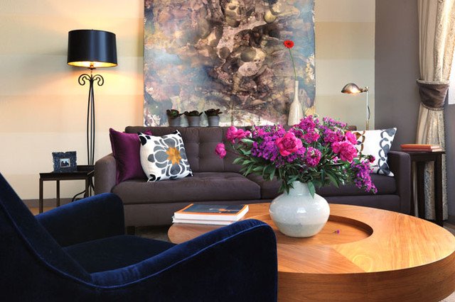 Some bright flowers and pillows contrast nicely with a sapphire blue chair 