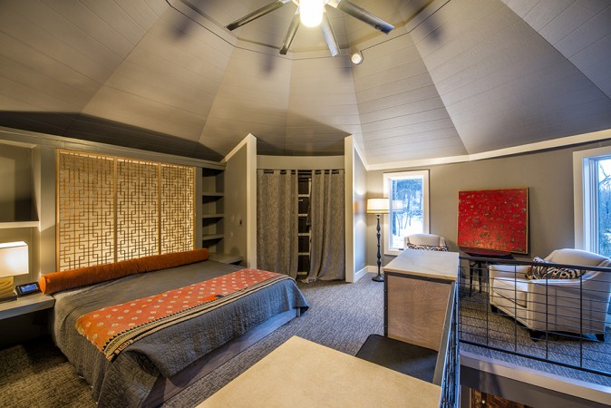 A bedroom with a ceiling fan.