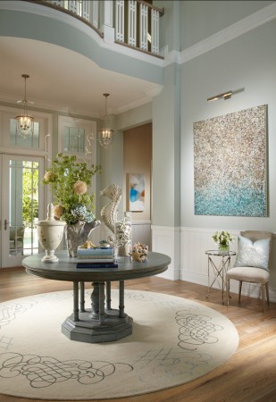 An elegant round table in an understated coastal foyer.