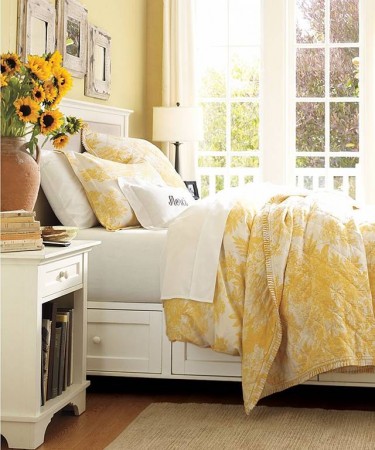 A yellow and white bedroom with sunflowers, showcasing things that make a house a home.