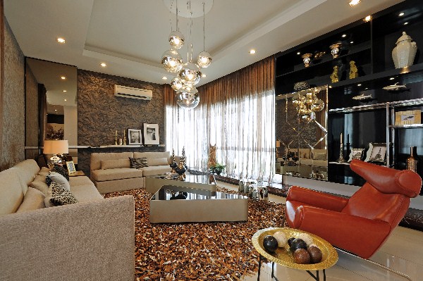 A modern living room with bold and wonderful brown furniture and a chandelier.