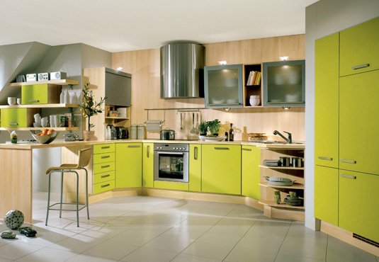 A kitchen with vibrant green cabinets and warm wooden counter tops.