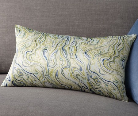 A trendy pillow with green and blue swirls on it.