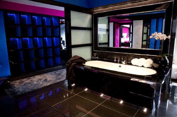 A black bathroom accented with dark jewel tones