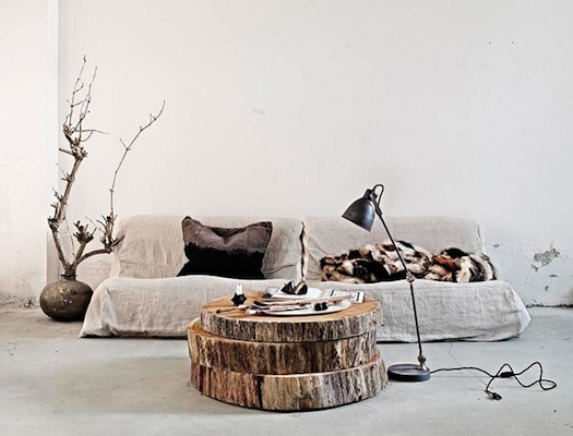 A cozy living room with a coffee table made from a tree trunk and a stylish lamp.