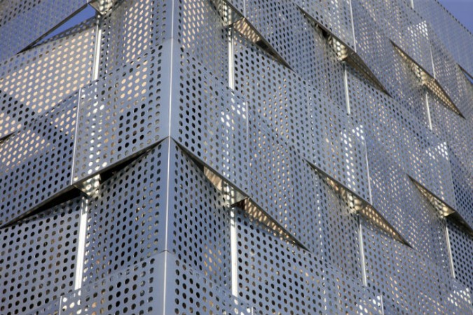 A close up of a building with perforated metal panels showcasing the trendy perforated design.