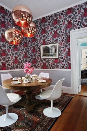 A dining room with bold and wonderful floral wallpaper.