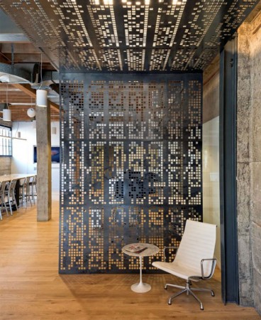 A modern office with metal dividers featuring a trendy perforated design.