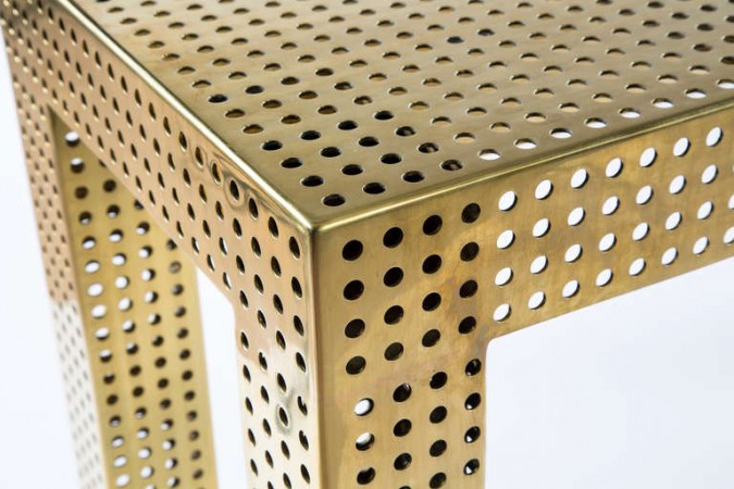 A trendy brass table with perforated design.