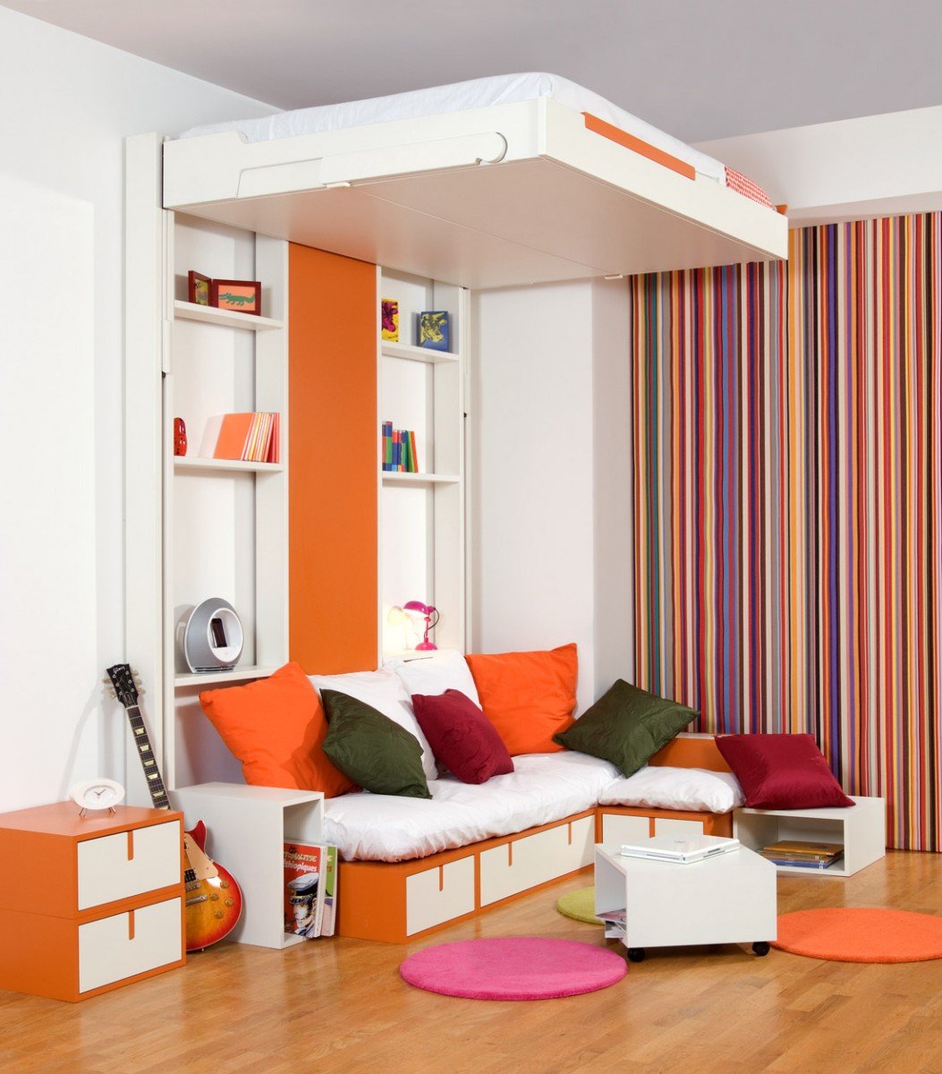 A space-saving orange and white room with a bed and a guitar.