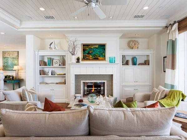 An elegant living room with understated coastal design featuring white furniture and a ceiling fan.