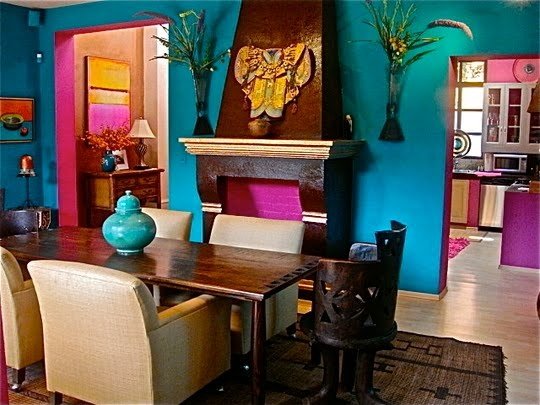 Bold turquoise walls and bright fuchsia accents enliven this dining area 