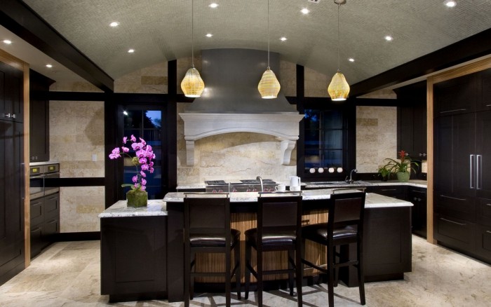 A modern kitchen with a center island and bar stools featuring marble countertops.