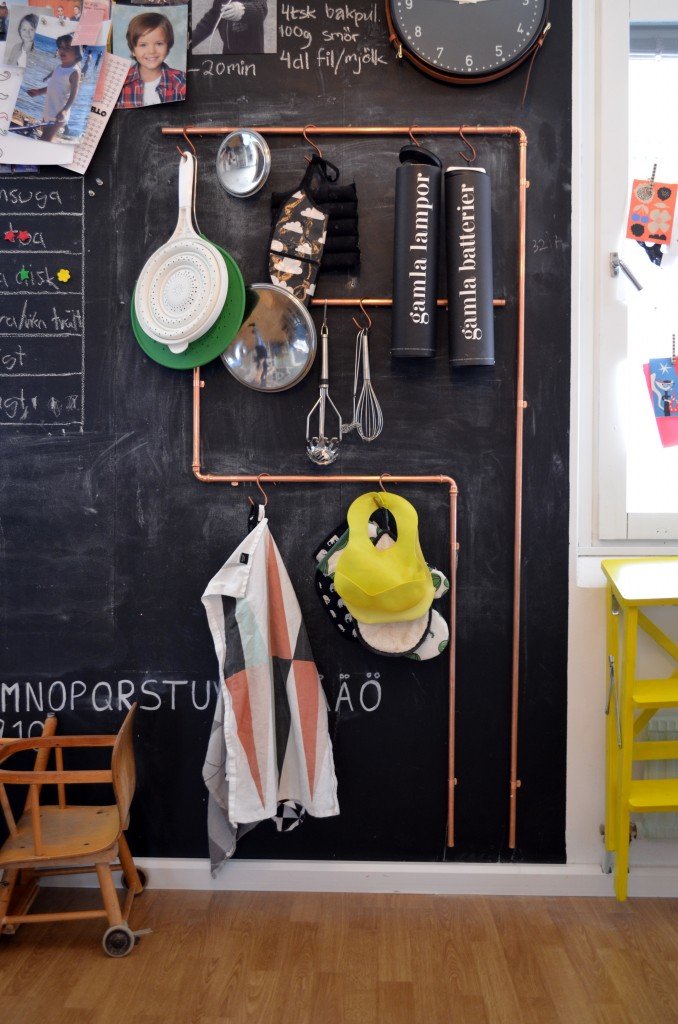 A child's room with a chalkboard wall and copper pipe accents.