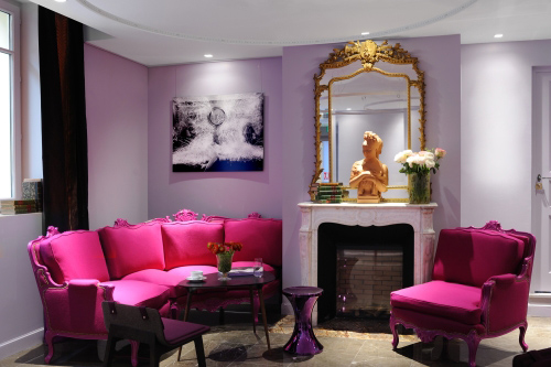 Bold and Wonderful living room with a pink couch and a fireplace to inspire.