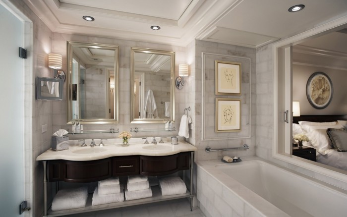 A bathroom with two sinks and two mirrors showcasing the beauty of marble.