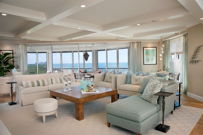 A living room with an elegant coastal design and a view of the ocean.