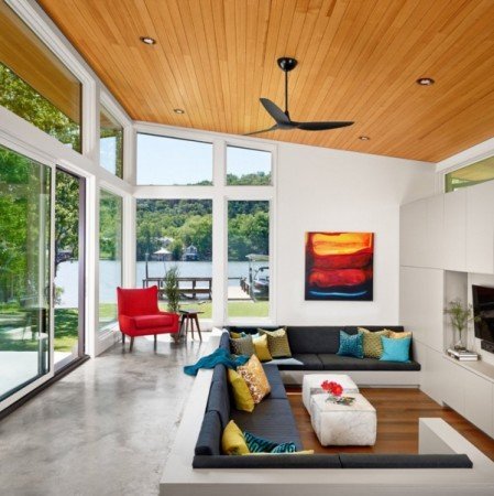 A modern living room with a ceiling fan in a lake home.