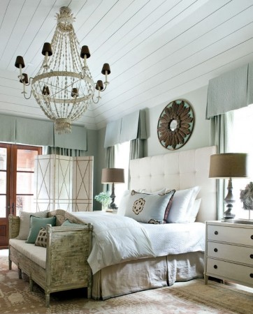 A serene and restful master bedroom with a bed, dresser, and a chandelier.