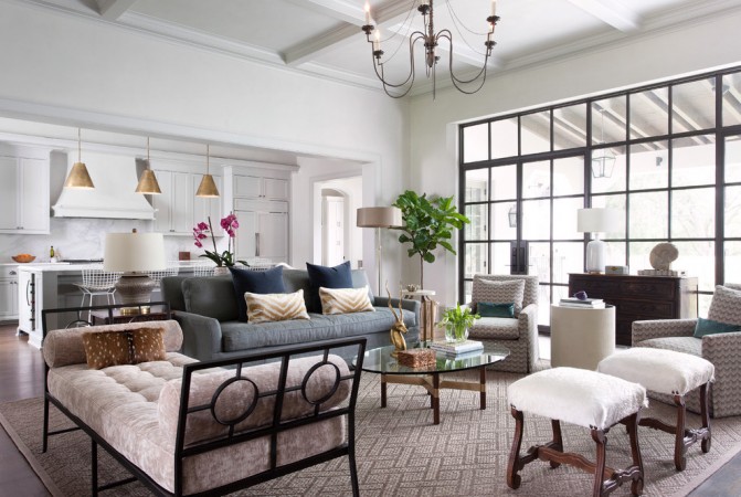 A fresh living room with large windows and a chandelier.