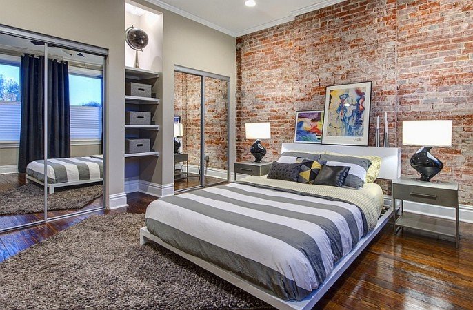 An exposed brick accent wall in the bedroom