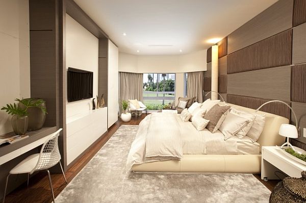 A modern bedroom with a large bed and a flat screen TV, creating a serene and restful atmosphere.
