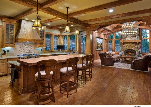 A lake home with a large kitchen featuring wood beams and a fireplace.