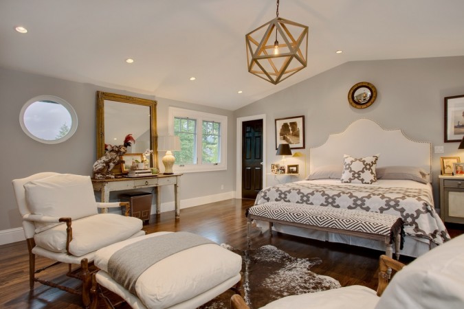A serene master bedroom with hardwood floors and a white bed.