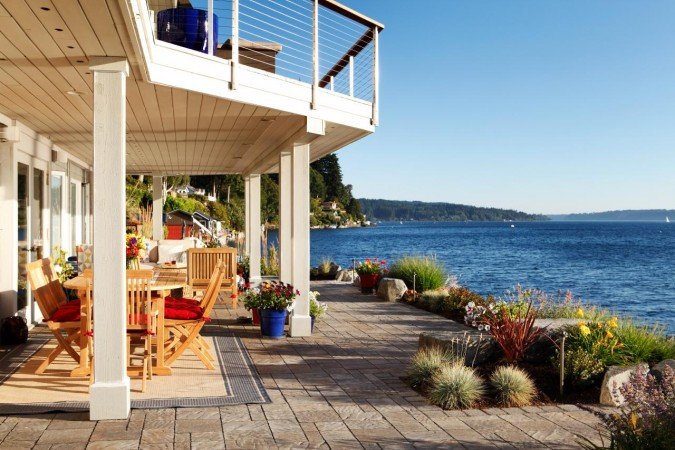 A lakefront deck with scenic water views and comfortable patio furniture.