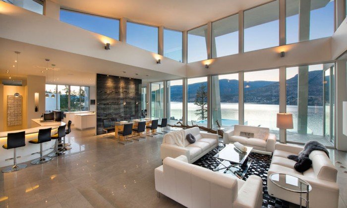 A spacious living room with expansive lake views through large windows.