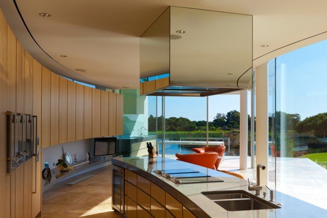 A modern kitchen with a glass wall in a lake home.