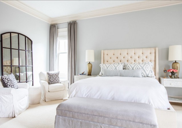 A serene and restful master bedroom with gray walls and white furniture.