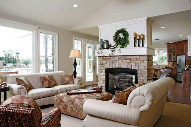 A cozy lakefront living room with a fireplace and comfortable couches.