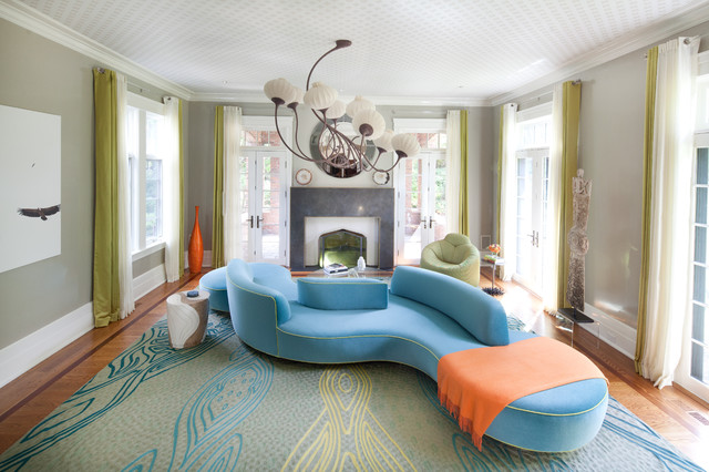 A living room with a modern blue couch and orange chair.