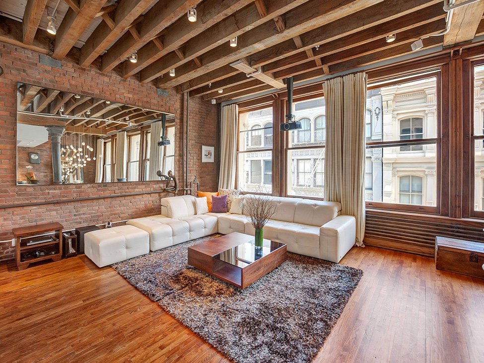 A living room with the charm of exposed brick and wooden floors.