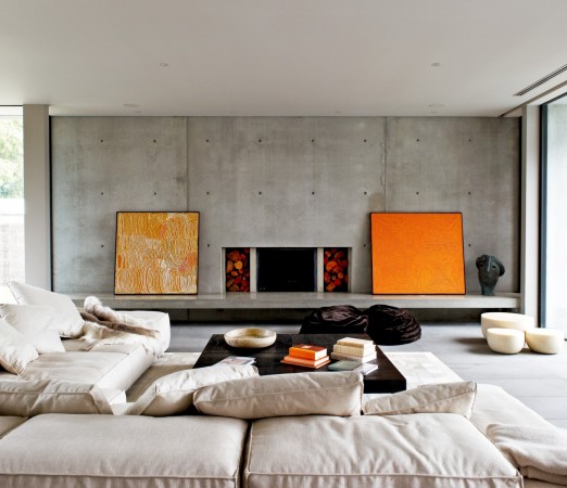 A modern living room with white couches and a fireplace.