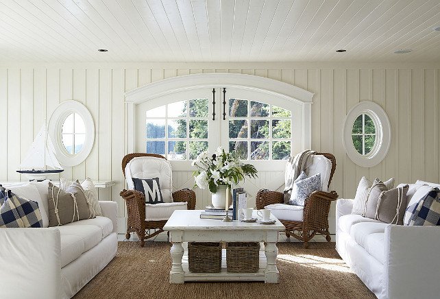 A white living room with wicker furniture in a lake home.