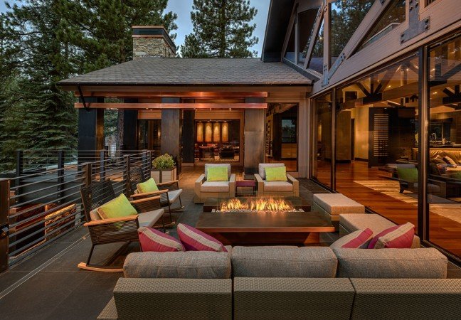A modern outdoor living area with a fire pit designed for Lake Home Interiors.