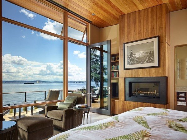 A bedroom with a large window overlooking the lake.