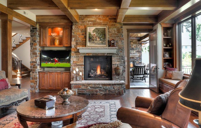 A cozy living room with a stone fireplace in a lake home.