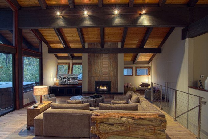 Lake Home Interiors: A cozy living room with wood beams and a fireplace.