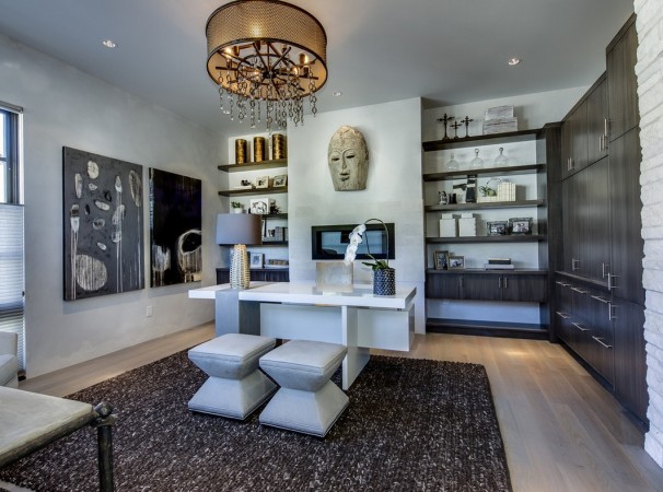 A fresh home office with a white desk and a chandelier.