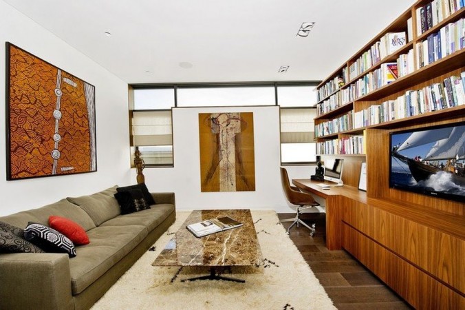 A living room with bookshelves and a couch transformed into an inspiring home office that breaks the mold.