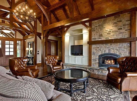 A lake house living room with wood beams and a stone fireplace.