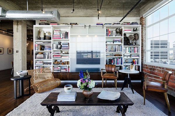 A living room with modern bookshelves and a coffee table.