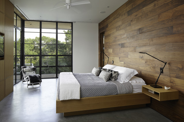 A serene bed in a room with a wooden wall.