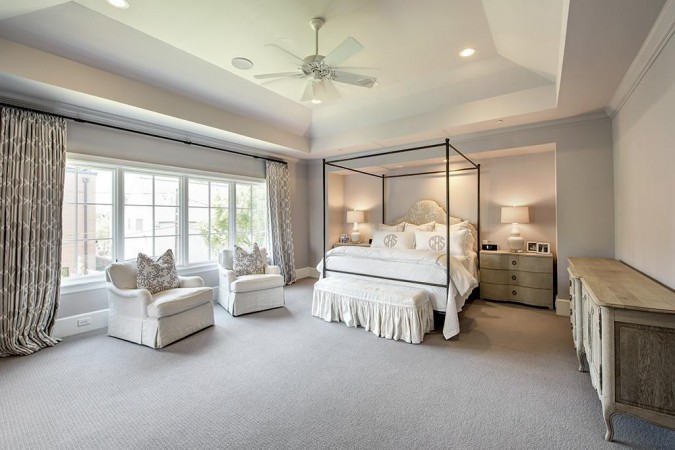 A serene and restful master bedroom with a ceiling fan and a bed.