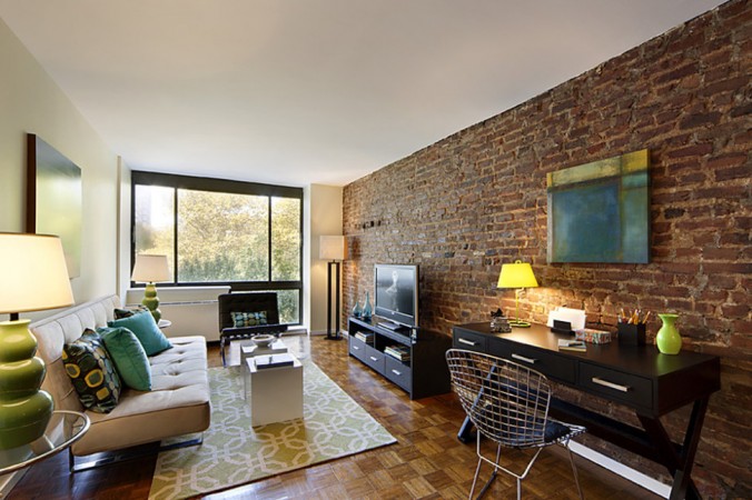 A living room with a brick wall that breaks the mold.