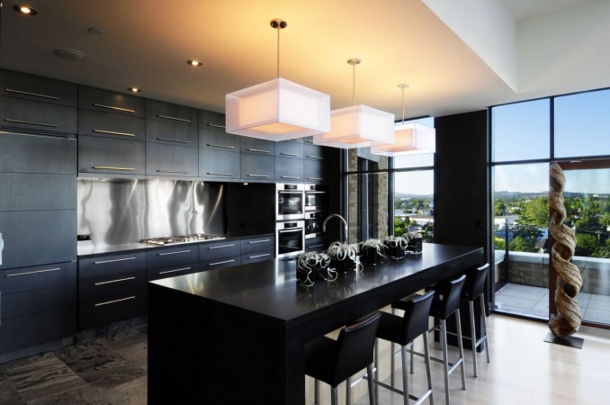 A modern kitchen with black cabinets, offering a breathtaking view of the city, and three reasons to love it!