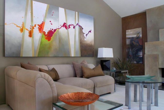 Modern living room with a large painting on the wall.